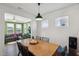 Bright dining area featuring a wooden table, black chairs, and a view into the well-lit sunroom at 115 Bourne Dr, Franklinton, NC 27525