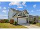 A side view of a two-story home highlighting the attached two-car garage and landscaping at 115 Bourne Dr, Franklinton, NC 27525