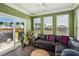 Inviting sunroom with dark wood floors, a comfortable leather sofa, and lots of natural light from sliding glass doors at 115 Bourne Dr, Franklinton, NC 27525
