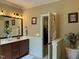 Bathroom with a double sink vanity, framed mirror, and a step up to the next room at 115 Oak Leaf Trl, Youngsville, NC 27596