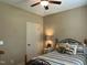 Cozy bedroom features a ceiling fan, striped bedding, and a warm, inviting ambiance at 115 Oak Leaf Trl, Youngsville, NC 27596