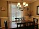 Elegant dining room with a classic chandelier, wood table, and large windows with natural light at 115 Oak Leaf Trl, Youngsville, NC 27596