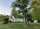 Exterior view showcasing a well-maintained home with mature trees and landscaping at 115 Oak Leaf Trl, Youngsville, NC 27596