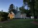 Dusk view of a home featuring a well-maintained lawn, trees and a backyard shed at 115 Oak Leaf Trl, Youngsville, NC 27596