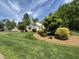 Beautifully landscaped front yard with lush lawn, mature trees, and an inviting home exterior at 115 Oak Leaf Trl, Youngsville, NC 27596