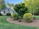 Charming home with a manicured lawn, mature trees, and stone accents on the facade at 115 Oak Leaf Trl, Youngsville, NC 27596
