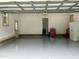 Clean garage features painted epoxy floors, access door, and room for vehicles at 115 Oak Leaf Trl, Youngsville, NC 27596