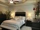 Comfortable main bedroom showcasing a tray ceiling and shiplap accent wall at 115 Oak Leaf Trl, Youngsville, NC 27596