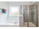 A relaxing bathroom offers a soaking tub and stand up shower with neutral color scheme at 115 River Chapel Dr, Fuquay Varina, NC 27526