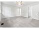 A bedroom with neutral walls, carpeted floor, ceiling fan, and three white doors at 122 Mallard Ct, Chapel Hill, NC 27517