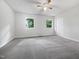 Spacious bedroom with ceiling fan, neutral walls, and carpeted floor with large windows at 122 Mallard Ct, Chapel Hill, NC 27517