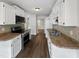Practical kitchen with white cabinets, stainless steel appliances, and wood flooring at 122 Mallard Ct, Chapel Hill, NC 27517