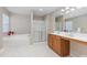 Bright bathroom featuring a soaking tub, glass shower, and a vanity with a light wood finish at 1220 Marbank St, Wake Forest, NC 27587
