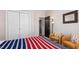 View of a bedroom showcasing a bed with red, white, and blue bedding, plus closet and doorway at 1220 Marbank St, Wake Forest, NC 27587