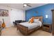 Stylish bedroom with a blue accent wall, and a wood-frame bed with comfortable furnishings at 1220 Marbank St, Wake Forest, NC 27587