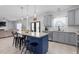 Open kitchen with a granite island, gray cabinets, stainless appliances, and a view into the living room at 1220 Marbank St, Wake Forest, NC 27587