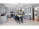 Wide view of the kitchen with an island with seating, gray cabinets, and stainless steel appliances at 1220 Marbank St, Wake Forest, NC 27587
