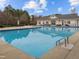 A community pool provides a refreshing escape, with a spacious deck and ample seating surrounded by lush landscaping and a clear blue sky at 1220 Marbank St, Wake Forest, NC 27587