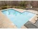An aerial shot showcases a pristine community pool featuring an inviting layout and complemented by its well-maintained surrounding landscape at 1220 Marbank St, Wake Forest, NC 27587