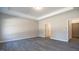 Bright bedroom featuring gray wood-look floors, tray ceiling and adjacent doorways at 1234 Pioneer Lot 3 Dr, Sanford, NC 27330