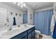 This bathroom has dual sinks, a shower curtain, and ample lighting at 1287 Salters St, Burlington, NC 27215