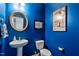 Chic powder room featuring bold blue walls, modern fixtures, and creative decor at 1287 Salters St, Burlington, NC 27215
