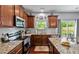 Well-equipped kitchen with granite countertops, stainless steel appliances, and backyard view from the window at 1287 Salters St, Burlington, NC 27215