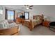 Cozy bedroom featuring wood furnishings, ceiling fan and large windows with coverings at 135 Campaign Dr, Mebane, NC 27302