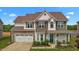 Charming two-story home features a two-car garage, landscaped yard, and a welcoming front porch at 135 Campaign Dr, Mebane, NC 27302