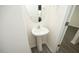 Clean pedestal sink with chrome faucet and round mirror, enhancing the powder room's minimalist charm at 139 Palm Drive Dr, Sanford, NC 27332