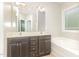 Bathroom showcasing double sink vanity, a large mirror, and a tiled tub at 175 Grist Mill Dr, Franklinton, NC 27525