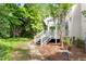 Landscaped backyard featuring a pergola-covered deck with stairs leading to a stone pathway at 1925 W Lake Dr, Burlington, NC 27215