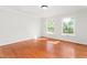 Bright bedroom featuring hardwood floors, crown molding, and natural light from large windows at 1925 W Lake Dr, Burlington, NC 27215
