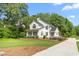 Stunning two-story white home boasting lush landscaping and a charming, curved driveway at 1925 W Lake Dr, Burlington, NC 27215
