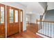 Bright foyer with a wood door, hardwood floors, and a staircase with gray carpet at 1925 W Lake Dr, Burlington, NC 27215