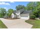 Side view of a two-story white home with a large driveway leading to an attached garage at 1925 W Lake Dr, Burlington, NC 27215