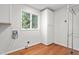 Bright laundry room with window, hardwood floors, and storage at 1925 W Lake Dr, Burlington, NC 27215