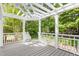 Covered patio with grey floors and white pillars overlooking trees at 1925 W Lake Dr, Burlington, NC 27215