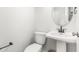 A clean and simple powder room with pedestal sink and round mirror at 1925 W Lake Dr, Burlington, NC 27215