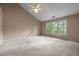 Spacious bedroom with vaulted ceiling, neutral carpet, and a large window overlooking the backyard at 206 Swiss Lake Dr, Cary, NC 27513