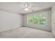Light-filled bedroom featuring neutral colors, carpet, and a large window view at 206 Swiss Lake Dr, Cary, NC 27513
