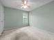 Carpeted bedroom featuring a ceiling fan and natural light from a window at 206 Swiss Lake Dr, Cary, NC 27513