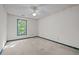 Spacious carpeted bedroom with ceiling fan and natural light from the window at 206 Swiss Lake Dr, Cary, NC 27513