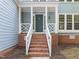 Inviting front entrance with brick stairs, white railings, and a covered porch area at 206 Swiss Lake Dr, Cary, NC 27513