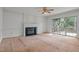 Living room with fireplace, ceiling fan, and sliding glass doors to patio at 206 Swiss Lake Dr, Cary, NC 27513
