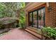 Exterior home view with brick paved patio, brick wall, double doors and water feature at 213 Old Franklin Grove Dr, Chapel Hill, NC 27514