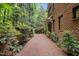 Exterior home view with brick paved patio, brick wall, and lush foliage at 213 Old Franklin Grove Dr, Chapel Hill, NC 27514