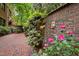 Brick wall, flowers and yard art adjacent to the brick paver patio at 213 Old Franklin Grove Dr, Chapel Hill, NC 27514