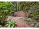 Backyard brick paver patio with custom brick wall, water feature, and mature plantings at 213 Old Franklin Grove Dr, Chapel Hill, NC 27514