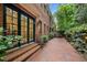 Exterior home view with brick paved patio, iron railing, and black framed double doors at 213 Old Franklin Grove Dr, Chapel Hill, NC 27514
